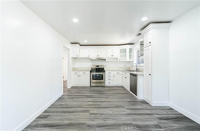 kitchen featuring white cabinets, light wood-type flooring, appliances with stainless steel finishes, and sink