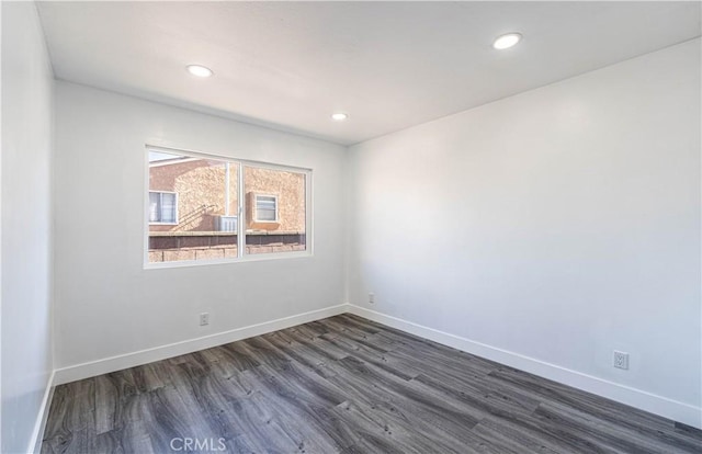 empty room with dark hardwood / wood-style flooring