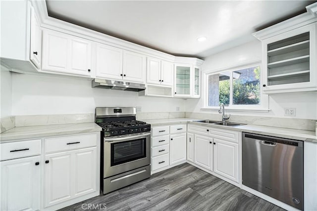 kitchen with light stone countertops, sink, white cabinetry, and stainless steel appliances