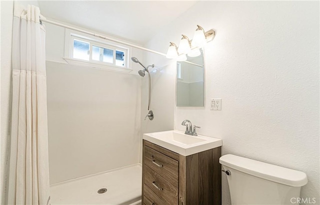 bathroom with walk in shower, vanity, and toilet