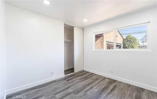 unfurnished bedroom featuring a closet and hardwood / wood-style floors