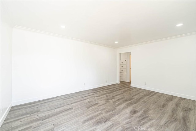 spare room with light wood-type flooring and crown molding