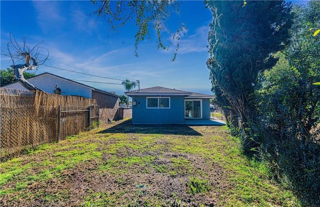 rear view of property with a yard