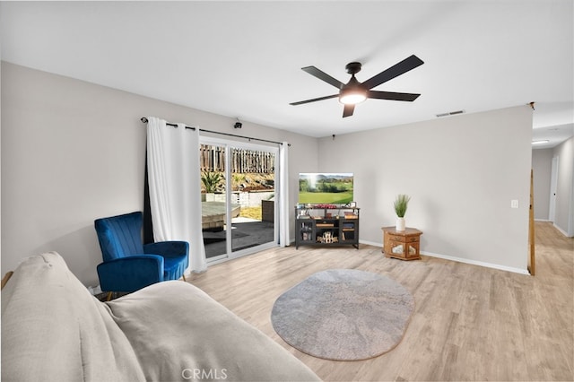 living area with light hardwood / wood-style floors and ceiling fan