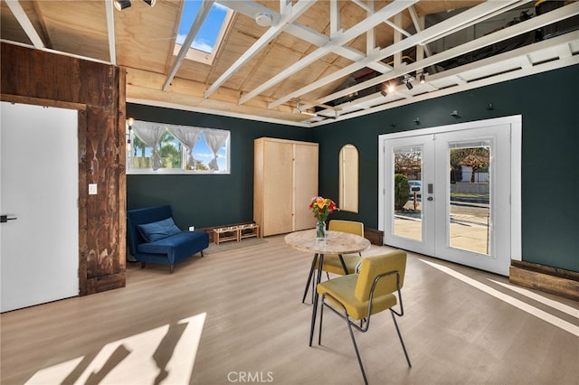 living area featuring wooden ceiling, vaulted ceiling with beams, french doors, and light hardwood / wood-style flooring