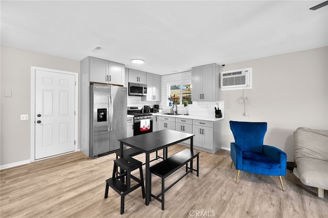 dining space with light hardwood / wood-style floors, sink, and a wall mounted air conditioner