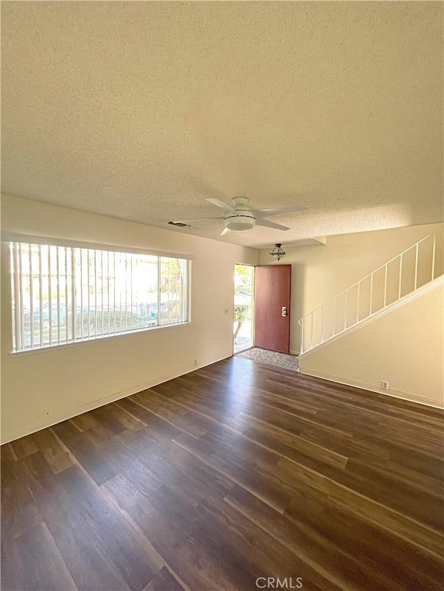 unfurnished room with ceiling fan, dark hardwood / wood-style flooring, and a textured ceiling