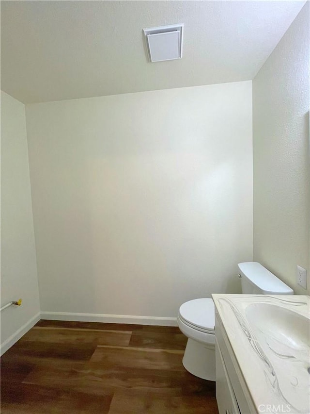 bathroom featuring hardwood / wood-style flooring, toilet, and vanity