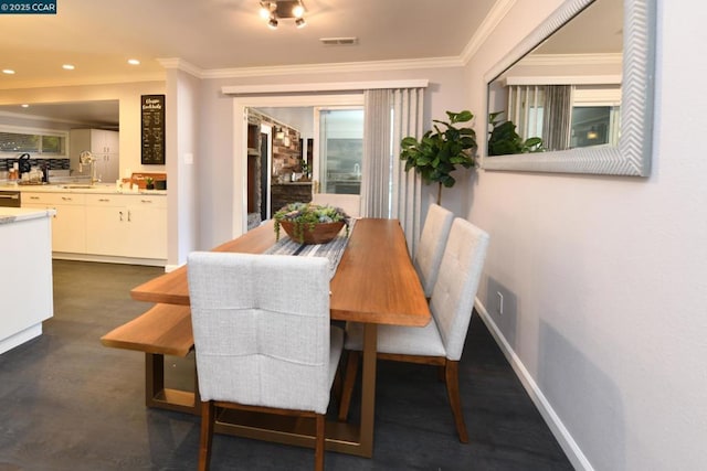 dining space with sink and ornamental molding