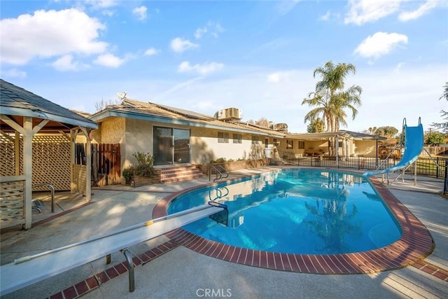 view of pool featuring a patio area, a diving board, and a water slide