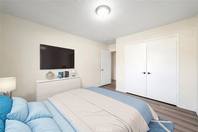 bedroom with dark hardwood / wood-style floors and a closet