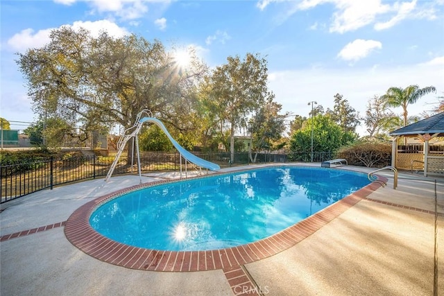 view of swimming pool with a gazebo, a water slide, a diving board, and a patio