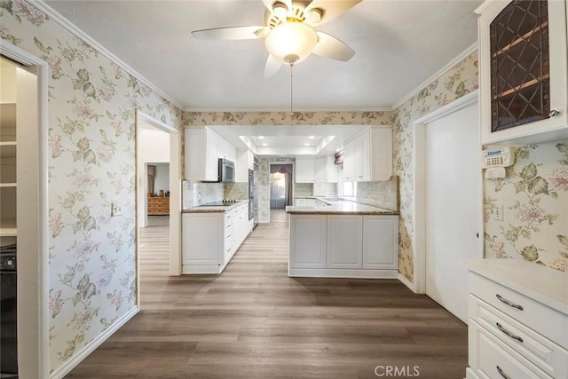 kitchen with ceiling fan, backsplash, ornamental molding, white cabinets, and dark hardwood / wood-style flooring