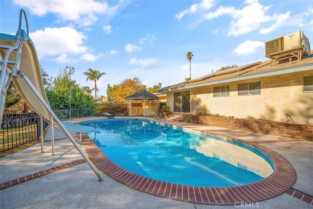 view of swimming pool featuring a patio area, central air condition unit, a gazebo, and a water slide