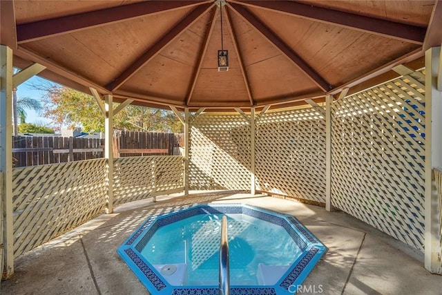 view of pool with a gazebo and an in ground hot tub