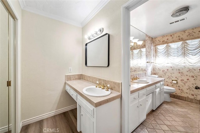 bathroom with toilet, vanity, and crown molding