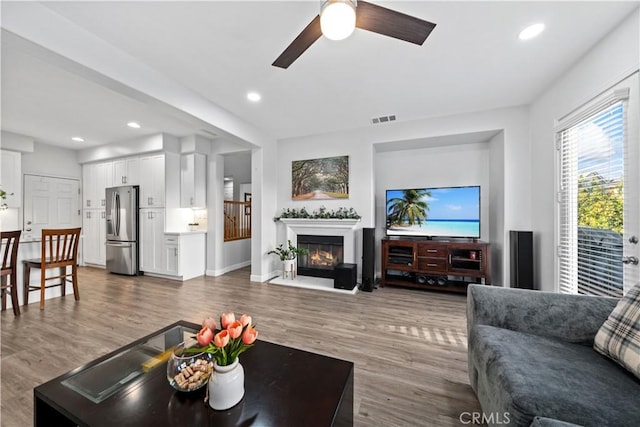 living room featuring dark wood-type flooring and ceiling fan