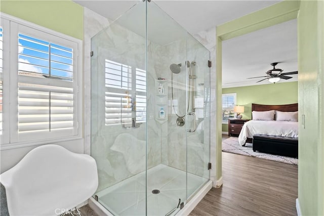 bathroom with wood-type flooring, a healthy amount of sunlight, ceiling fan, and a shower with shower door