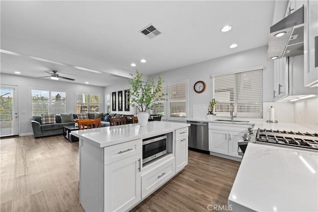 kitchen featuring a kitchen island, appliances with stainless steel finishes, and white cabinets