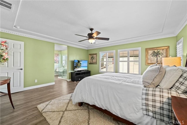 bedroom featuring crown molding, dark wood-type flooring, ceiling fan, and ensuite bath