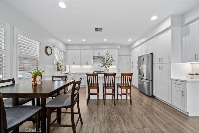 dining space with sink and light hardwood / wood-style flooring