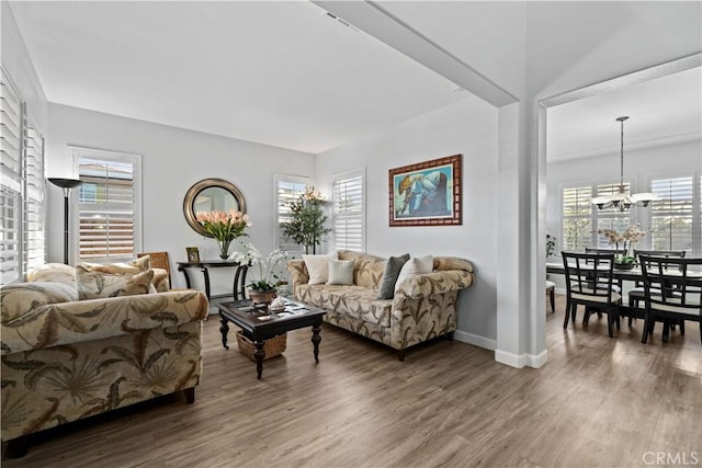 living room featuring hardwood / wood-style flooring, plenty of natural light, and an inviting chandelier