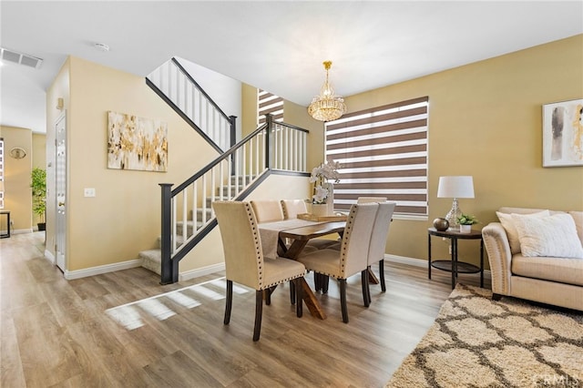 dining room featuring light wood-type flooring and a notable chandelier