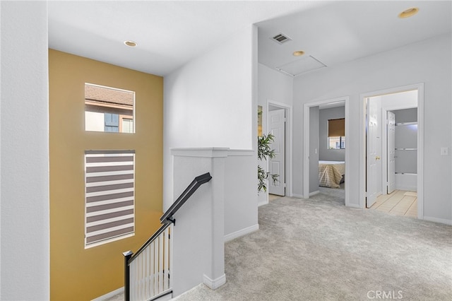 hallway featuring light colored carpet