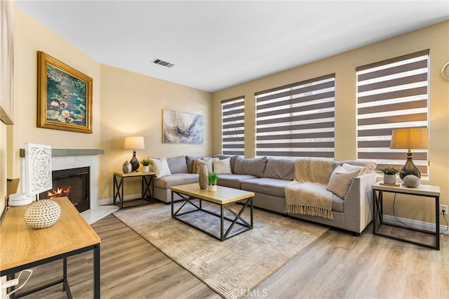 living room with light wood-type flooring and a fireplace