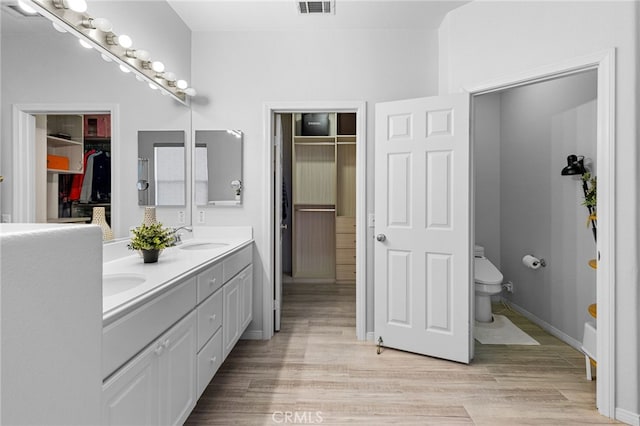 bathroom with toilet, vanity, and hardwood / wood-style flooring