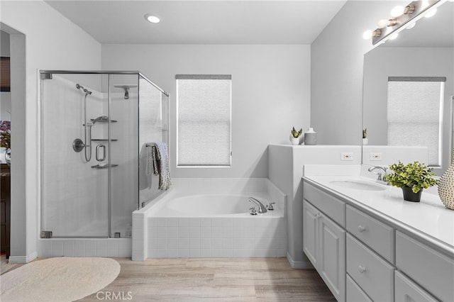 bathroom with vanity and shower with separate bathtub