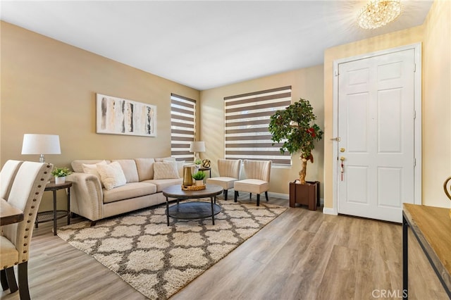 living room with a chandelier and light hardwood / wood-style flooring