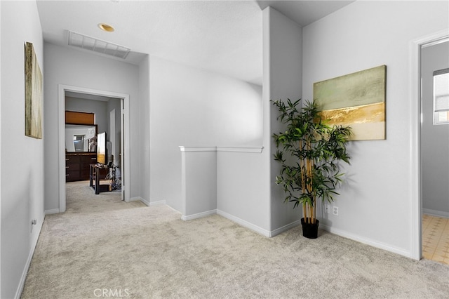 hallway featuring light colored carpet