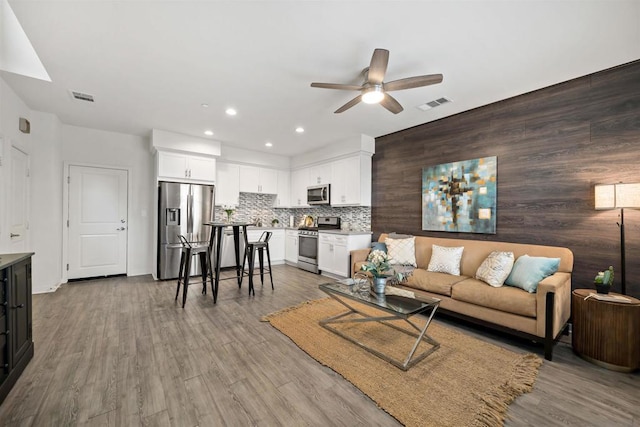 living room featuring ceiling fan and hardwood / wood-style flooring