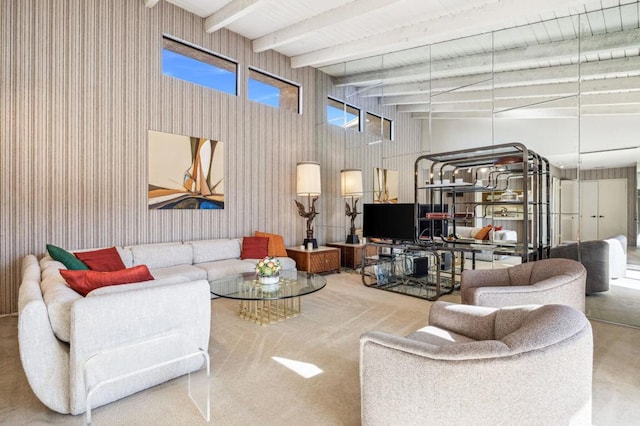 carpeted living room featuring a high ceiling, beam ceiling, and wooden walls