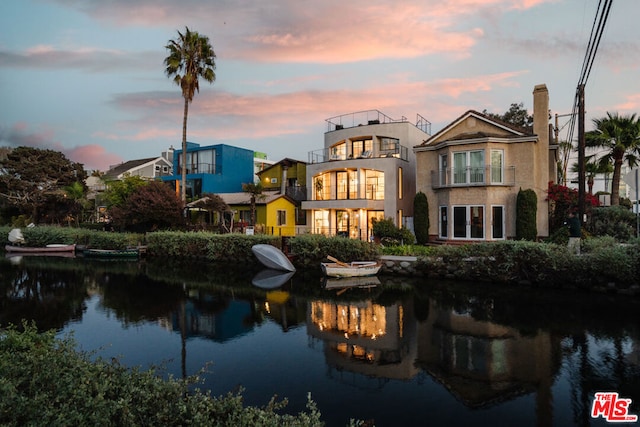 back house at dusk featuring a water view