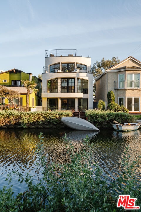 back of property featuring a water view