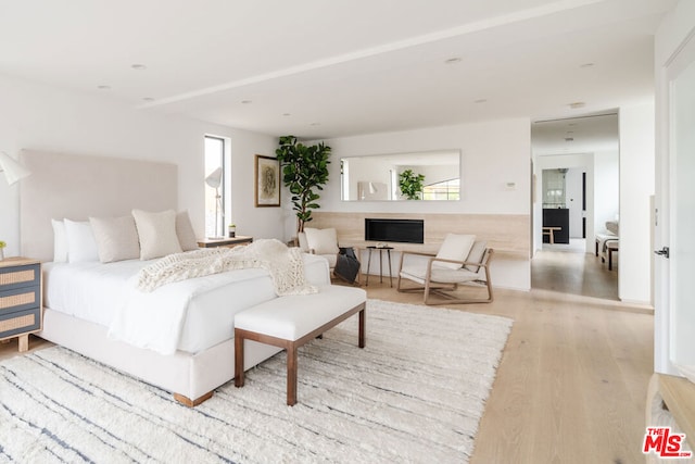 bedroom with multiple windows and light hardwood / wood-style floors