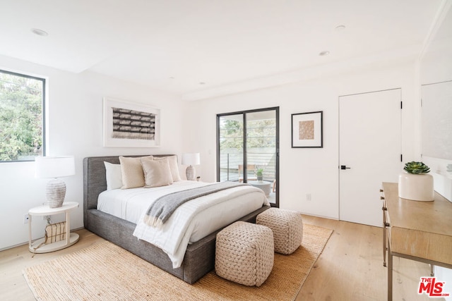 bedroom featuring wood-type flooring and access to outside