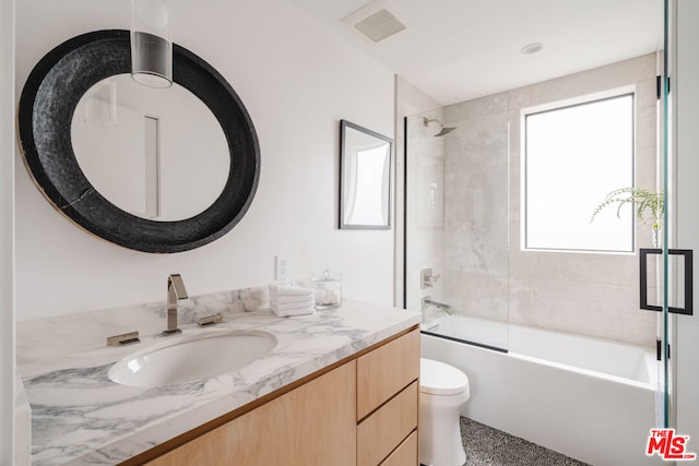 full bathroom with toilet, enclosed tub / shower combo, and vanity