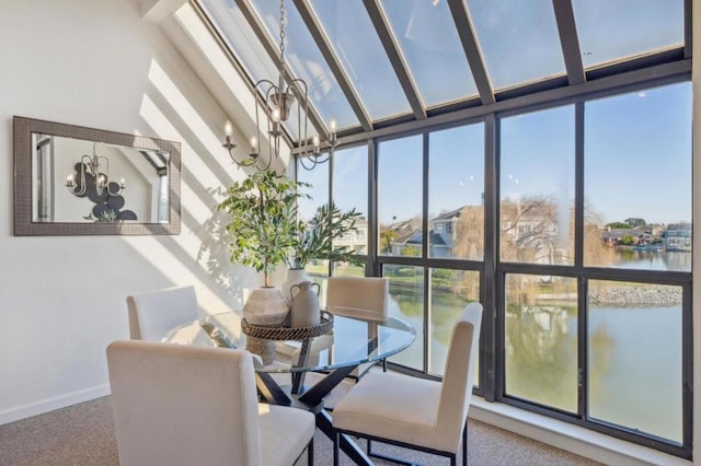 sunroom featuring a water view, plenty of natural light, and a chandelier