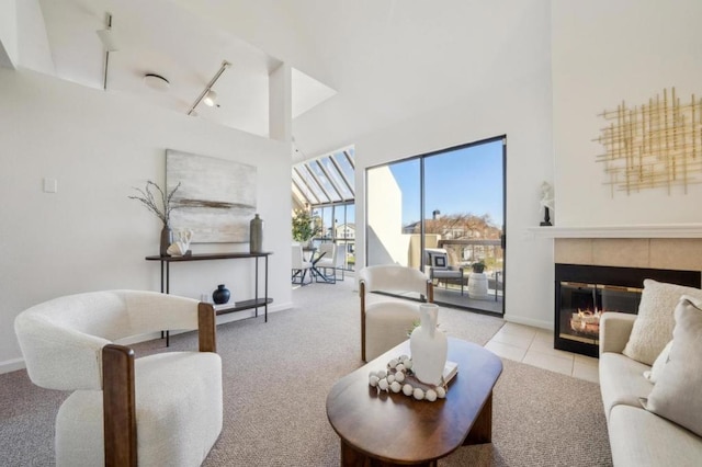 carpeted living room with rail lighting and a tiled fireplace