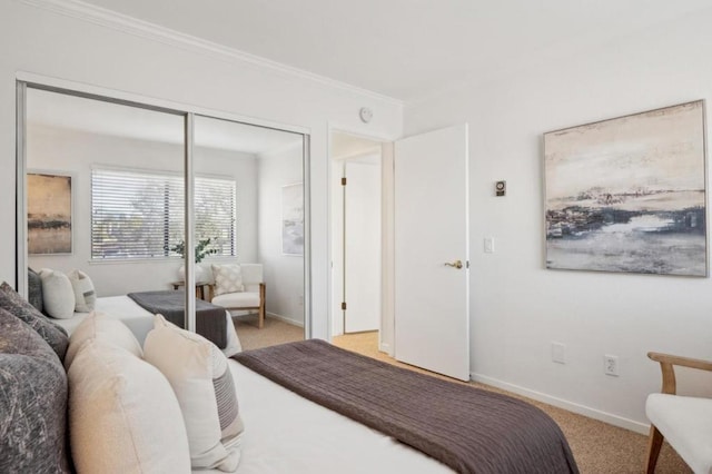 carpeted bedroom with a closet and crown molding