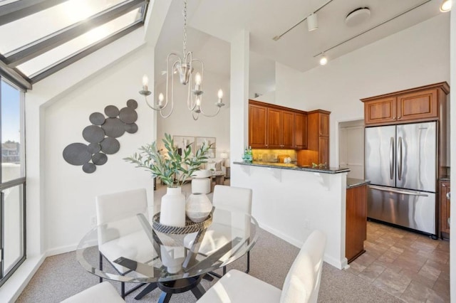 dining room featuring rail lighting and a chandelier