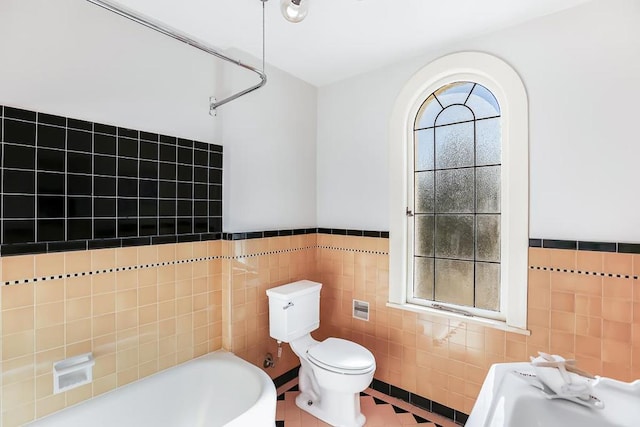 full bathroom with tile patterned floors, tile walls, sink, toilet, and shower / bathing tub combination