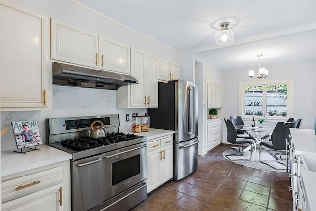 kitchen with a chandelier, stainless steel appliances, white cabinetry, and hanging light fixtures