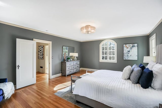 bedroom with crown molding and light hardwood / wood-style flooring