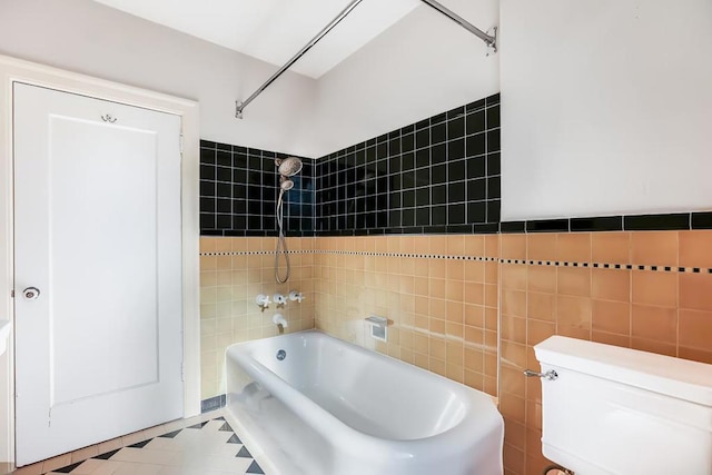 bathroom featuring toilet, bathtub / shower combination, and tile walls