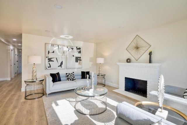 living room with light wood-type flooring and a fireplace