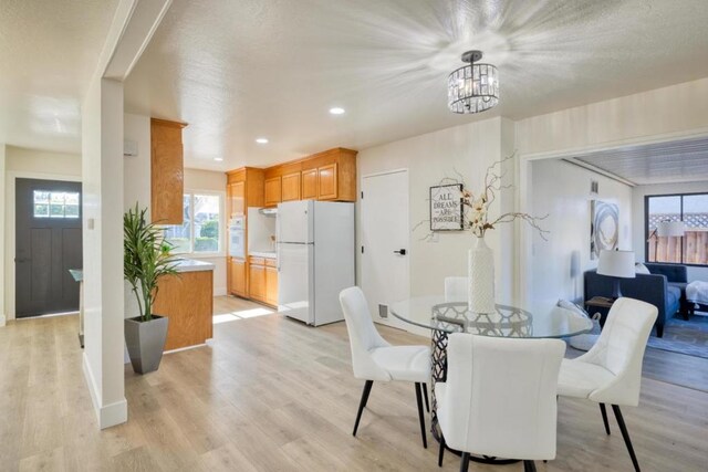 dining room featuring light wood-type flooring and a notable chandelier